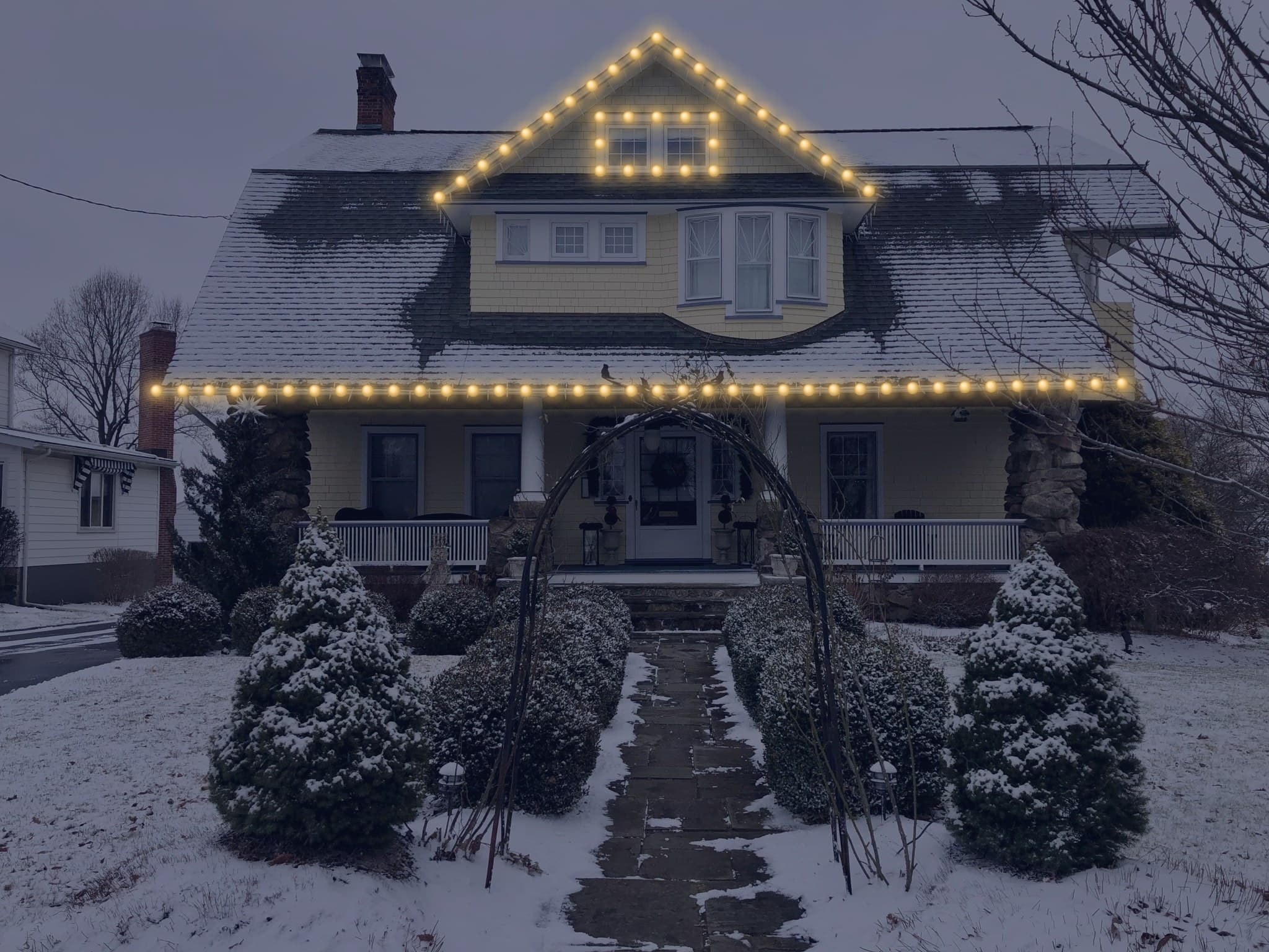 An example house in the visualizer's Night view, with warm white lights along its rooflines and around the upper windows.